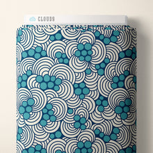 Load image into Gallery viewer, Bolt of Organic Cotton fabric with abstract waves and bubbles print, lays against wall