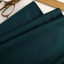 Load image into Gallery viewer, Organic cotton poplin fabric displayed in soft folds, among a pair of scissors and a wooden ruler