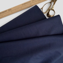 Load image into Gallery viewer, Organic cotton poplin fabric displayed in soft folds next to a wooden ruler and pair of scissors