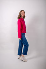 Load image into Gallery viewer, Side view of model wearing a loose-fitting jacket with sunburst tucks around the neckline, and patch pockets