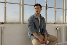 Load image into Gallery viewer, Man sits by window wearing the Painter Jacket open, over a plain tee, long sleeves pushed up at elbows.