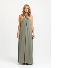 Load image into Gallery viewer, Lady stands wearing a dress with cross-over halter neck strap