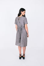 Load image into Gallery viewer, Back view of lady wearing short sleeved, knee length dress with waist belt ties
