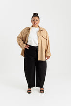 Load image into Gallery viewer, Lady wears a long sleeved, button up shirt with patch pockets at chest, worm open with a plain tee underneath