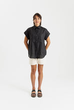 Load image into Gallery viewer, Lady wears a short sleeved, button up shirt with patch pockets at chest