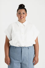 Load image into Gallery viewer, Lady wears a short sleeved, button up shirt with patch pockets at chest, worn tucked into trousers