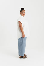 Load image into Gallery viewer, Side view of lady wearing a short sleeve shirt, curved hem at thigh level