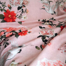 Load image into Gallery viewer, Viscose Fabric with oversized blooms amongst storks mid-flight pattern, displayed with ripples showing fluid drape
