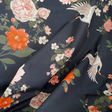 Load image into Gallery viewer, Cotton fabric with oversized blooms, and storks in mid-flight pattern, displayed with soft folds