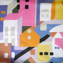 Load image into Gallery viewer, Cotton Lawn fabric with a colourful abstract pattern of geometric shapes resembling buildings, displayed flat