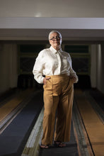 Load image into Gallery viewer, Lady wears a collared shirt tucked into a pair of tailored trousers with front creased folds