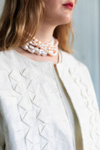 Load image into Gallery viewer, Close up detail of chest, of model wearing an open jacket with origami folded pleat styling on chest