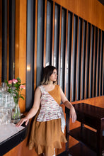 Load image into Gallery viewer, Lady wears a sleeveless assymetrical dress with two different fabrics, and frill hem.