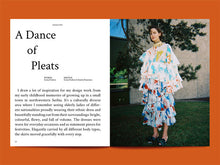 Load image into Gallery viewer, Magazine Spread of article titled "A Dance of Pleats" next to photo of lady wearing a dress with layers of ruffles and pleats