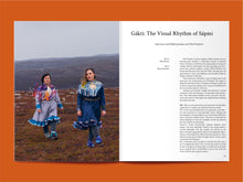 Load image into Gallery viewer, Magazine spread with photo of two ladies amongst mountain top, alongside article titled: "Gákti: The Visual Rhythm of Sápmi".