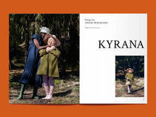 Load image into Gallery viewer, Magazine spread features two ladies hugging, both wearing a dress with gathered tier at hem, next to title: "Kyrana".