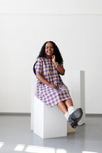 Load image into Gallery viewer, Lady sits on block wearing a checkered dress with tulip sleeves