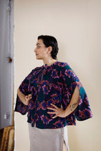 Load image into Gallery viewer, Lady stands with hands on hips, wearing a cape-like shirt in floral print