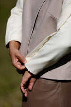 Load image into Gallery viewer, Close-up of a person wearing a jacket with sleeve and overlap placket detail