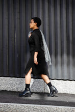 Load image into Gallery viewer, Mdel in a fitted dress, knee-length with small side split, walking