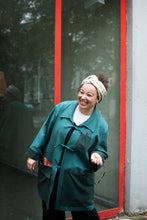 Load image into Gallery viewer, Lady stands by window laughing, wearing a overshirt jacket with three ties at centre front as fastenings