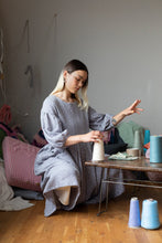 Load image into Gallery viewer, Lady crouches by table playing with yarn spool, wears a loose fitting gathered skirt dress