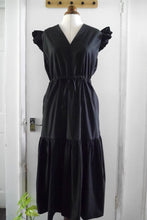 Load image into Gallery viewer, V-neck dress with flutter shoulder detail, and tiered gathered skirt, with waist tie, displayed on mannequin