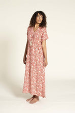 Load image into Gallery viewer, Side view of model wearing Abby Dress View A: a V-neck, straight skirt maxi dress with waist tie