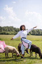 Load image into Gallery viewer, Lady strikes a pose mid-walk to show off cropped trousers with panel detail in a different fabric at the sides