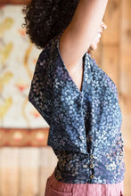 Load image into Gallery viewer, Side view detail of lady with hands in the air, showing off shirt detail of excess fabric panel underarm folded onto itself secured with three buttons down towards the hem of the side seam