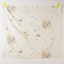 Load image into Gallery viewer, Square piece of Organic Cotton Double Gauze fabric hangs on a wall by two pieces of tape at the top two corners, displays a floral print
