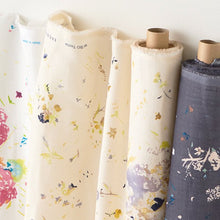 Load image into Gallery viewer, Fabric bolts slightly rolled out against the wall, shows Organic Cotton Double Gauze fabric with floral print
