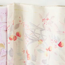 Load image into Gallery viewer, Fabric bolt rolled out against the wall of organic cotton double gauze fabric showing watercolour print of cherry-like fruits in petals