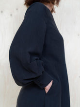 Load image into Gallery viewer, Close up view of puff sleeve with cuff. Lady has hand in pocket