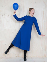 Load image into Gallery viewer, Lady balances on one leg wearing midi dress with straight long sleeves shows a-line skirt