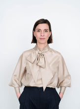 Load image into Gallery viewer, Front view of Tie Bow Blouse worn tucked into trousers