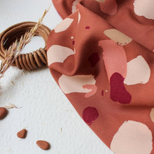 Load image into Gallery viewer, Viscose fabric sits softly crumply next to small pebbles