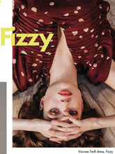 Load image into Gallery viewer, Lady lays on floor, wears a pleated V-neck dress made from the Fizzy Rust EcoVero Viscose Twill fabric