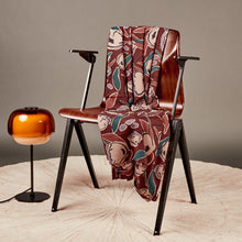 Load image into Gallery viewer, Peony Rust Ecovero Viscose fabric draped over a wooden chair next to a floor lamp