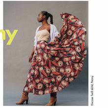 Load image into Gallery viewer, Lady stands wearing a skirt made of Peony Rust EcoVero Viscose Fabric, held up to show bold floral print