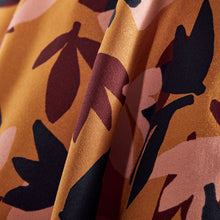 Load image into Gallery viewer, Close up of Seraphine Ochre EcoVero Viscose fabric, shows a soft drape with crocus print pattern