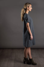 Load image into Gallery viewer, Side view of lady standing, wearing a knee-length dress cut with with raglan sleeves.