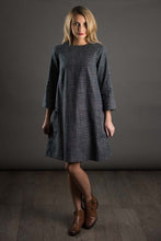 Load image into Gallery viewer, Lady stands wearing a just-above-knee-length dress cut with with raglan sleeves.