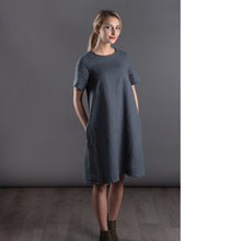 Load image into Gallery viewer, Front view of lady wearing knee length dress with raglan sleeves, hands in pockets.
