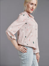 Load image into Gallery viewer, Side view of lady wearing The Blouse loosely tucked into trousers, hand on hip.