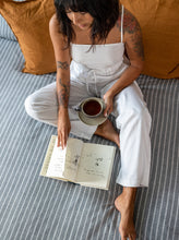 Load image into Gallery viewer, Lady sat in bed with tea and book, wearing The Pyjama Bottoms