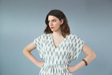 Load image into Gallery viewer, Lady with hands on hips wear a v-neck top with a central band at waist line