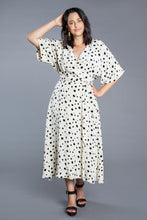 Load image into Gallery viewer, Lady wears a midi length Elodie Wrap Dress with elbow length sleeves