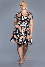 Load image into Gallery viewer, Lady wears a mini skirt length Elodie Wrap Dress with hand in pocket