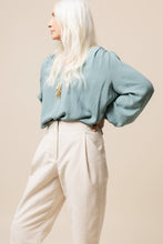 Load image into Gallery viewer, Lady wears tapered Mitchell Trousers, with hand on hip, shows a pleat at front waist, with a slanted pocket.